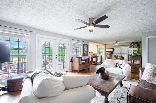 living room featuring wood-type flooring, a textured ceiling, and french doors