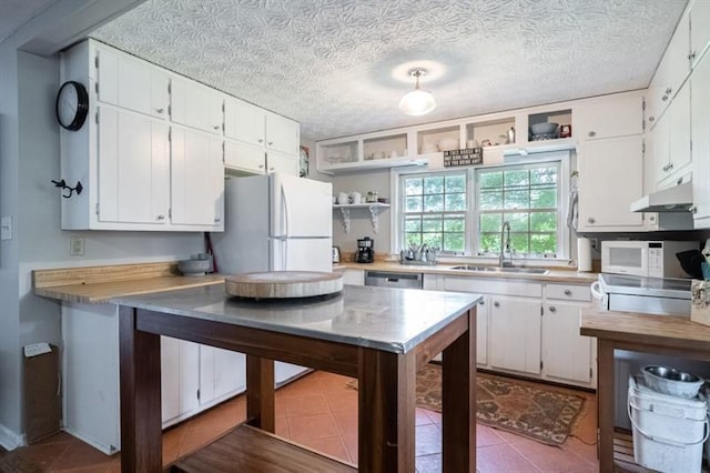 kitchen featuring white appliances, a textured ceiling, white cabinetry, and sink