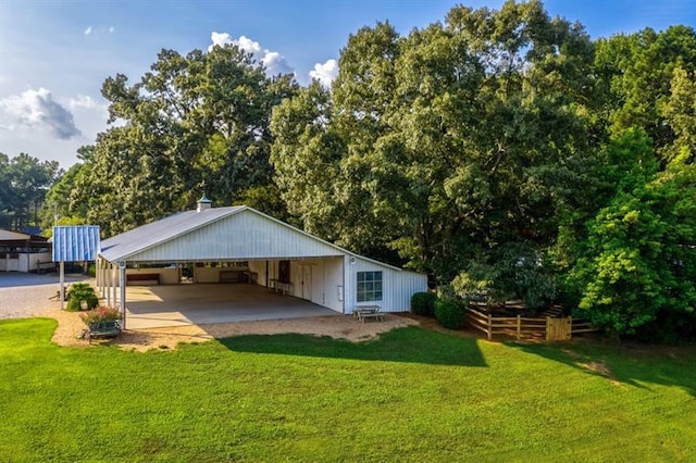 rear view of property with a carport and a lawn