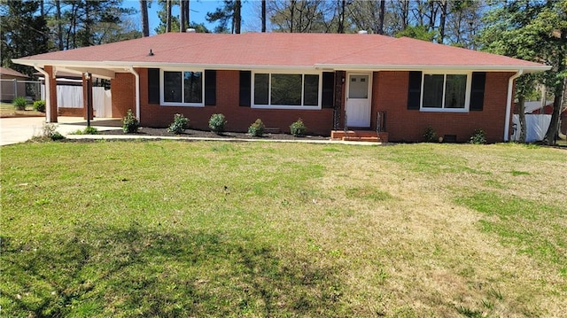 ranch-style home featuring an attached carport, a front yard, and fence