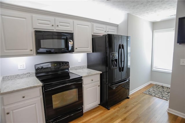 kitchen featuring white cabinets, a textured ceiling, and black appliances