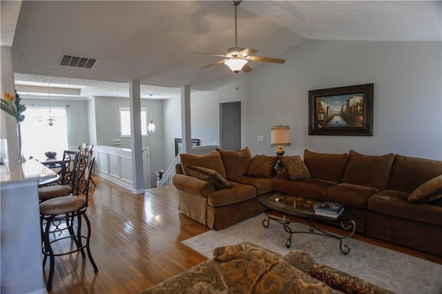 living room with wood-type flooring, vaulted ceiling, and ceiling fan