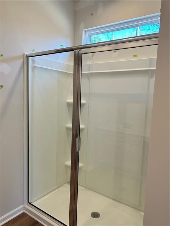 bathroom featuring hardwood / wood-style floors and an enclosed shower