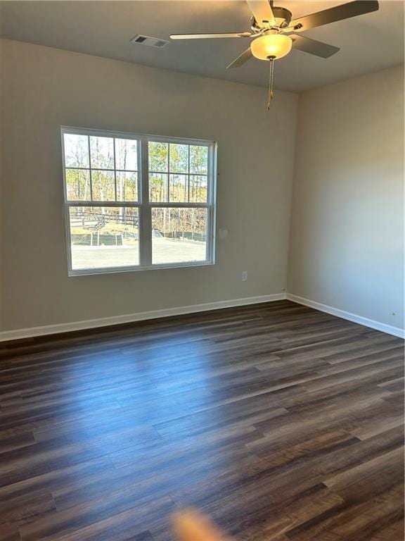 spare room with ceiling fan and dark hardwood / wood-style floors