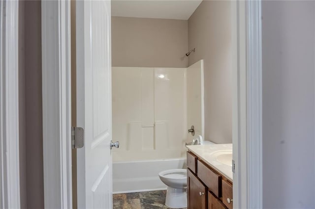 bathroom with  shower combination, stone finish floor, vanity, and toilet