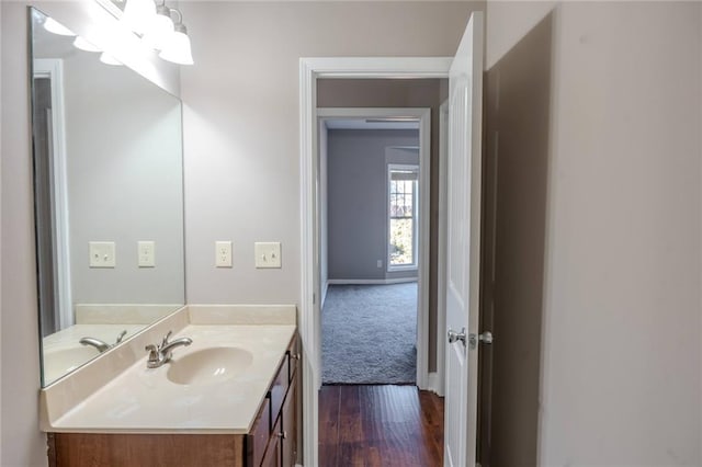 bathroom with wood finished floors, vanity, and baseboards