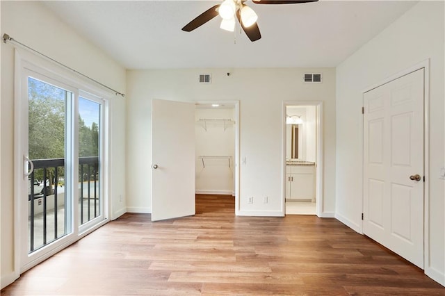 587 Virginia Ave NE Unit 315, Atlanta, GA 30306 - unfurnished bedroom with a walk in closet, access to exterior, visible vents, and light wood-type flooring