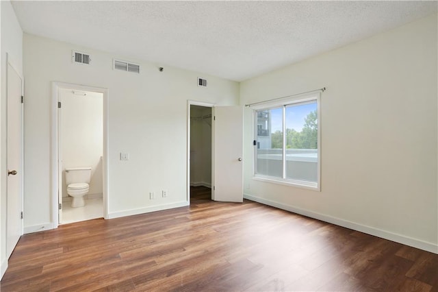 587 Virginia Ave NE Unit 315, Atlanta, GA 30306 - unfurnished bedroom featuring visible vents, a textured ceiling, and wood finished floors