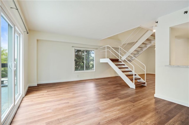 587 Virginia Ave NE Unit 315, Atlanta, GA 30306 - unfurnished living room with stairway, baseboards, and light wood-style floors