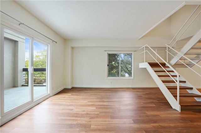 587 Virginia Ave NE Unit 315, Atlanta, GA 30306 - unfurnished living room with stairs, baseboards, and light wood-type flooring