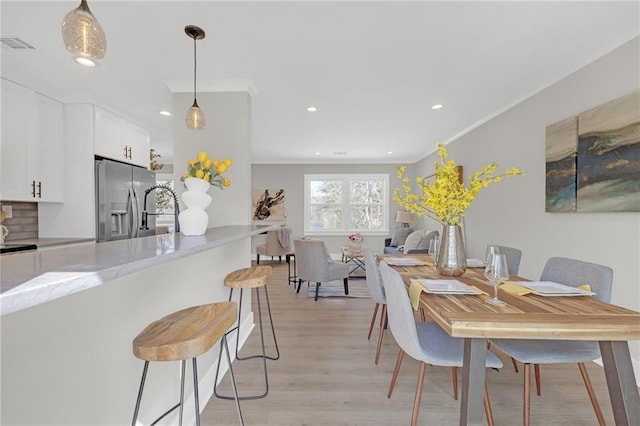 dining room featuring recessed lighting, visible vents, ornamental molding, and light wood-style flooring