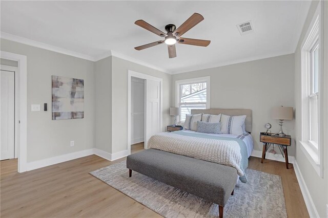 bedroom with ornamental molding, baseboards, visible vents, and light wood-type flooring