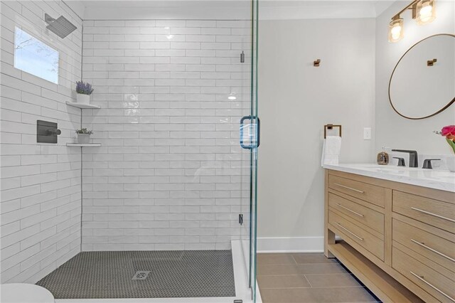 full bathroom with vanity, baseboards, a stall shower, and tile patterned flooring