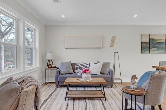 living room with recessed lighting, baseboards, and light wood-type flooring