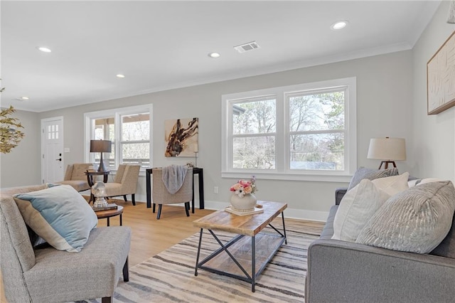 living room featuring visible vents, recessed lighting, light wood-style flooring, and ornamental molding