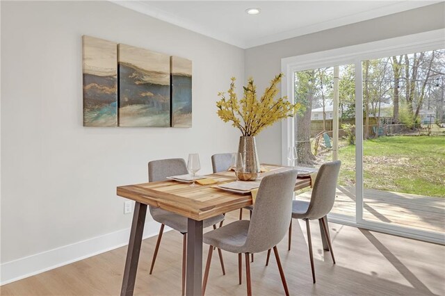 dining area with ornamental molding, recessed lighting, baseboards, and light wood-type flooring