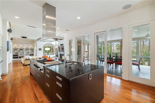 4835 Merlendale Ct, Atlanta, GA 30327 - kitchen with island range hood, a spacious island, a sink, and light wood-type flooring