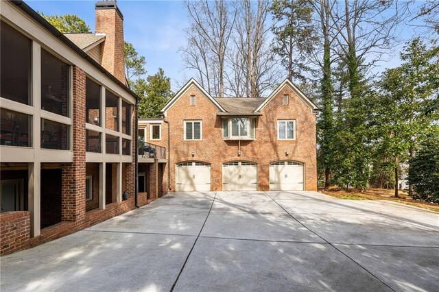 4835 Merlendale Ct, Atlanta, GA 30327 - view of front of home with driveway, a chimney, brick siding, and a garage