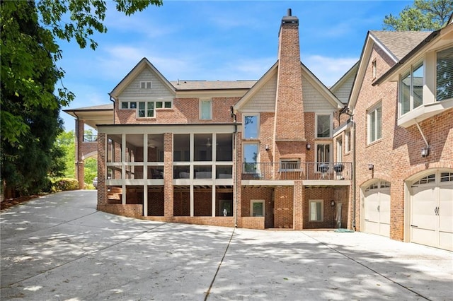 4835 Merlendale Ct, Atlanta, GA 30327 - back of property with concrete driveway, an attached garage, brick siding, and a chimney