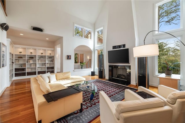 4835 Merlendale Ct, Atlanta, GA 30327 - living room featuring arched walkways, a high ceiling, wood finished floors, and a fireplace