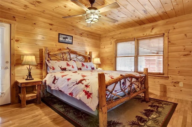 bedroom with wooden walls, wooden ceiling, ceiling fan, and wood finished floors