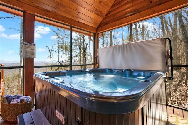 sunroom / solarium featuring vaulted ceiling, a jacuzzi, and a healthy amount of sunlight