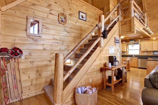 stairs with wooden ceiling, wooden walls, and wood-type flooring