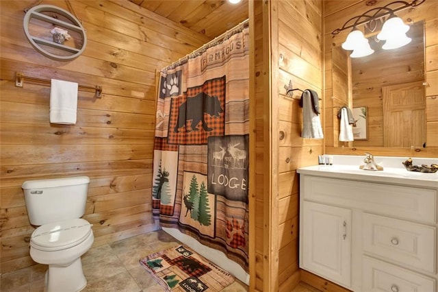 full bathroom featuring curtained shower, toilet, wood walls, and vanity