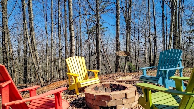 view of patio / terrace featuring a wooded view and a fire pit