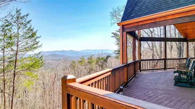 wooden terrace featuring a view of trees and a mountain view