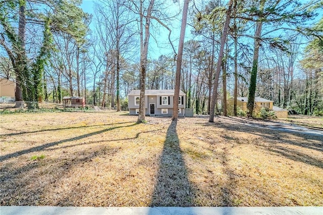 split foyer home featuring a front lawn and an outdoor structure