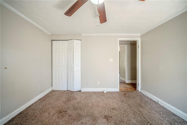 unfurnished bedroom with crown molding, baseboards, and carpet flooring