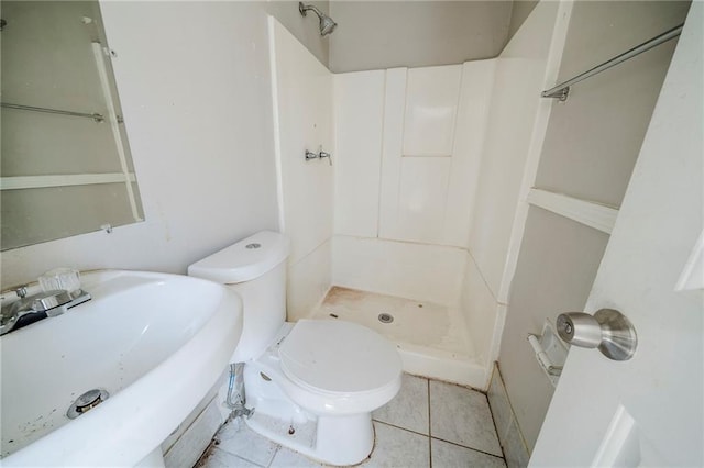 full bath featuring a stall shower, tile patterned flooring, a sink, and toilet