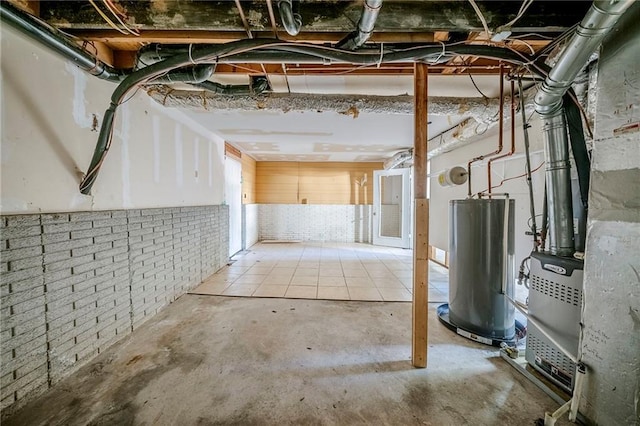 basement featuring brick wall and water heater