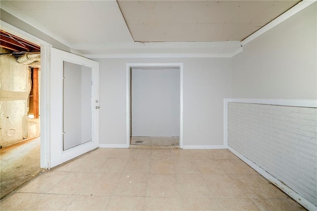 spare room with baseboards and light tile patterned floors