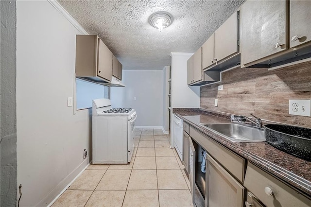 kitchen with dark countertops, white appliances, light tile patterned floors, and a sink