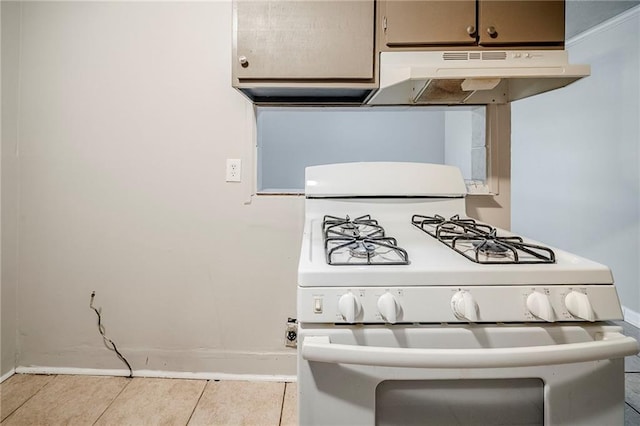 kitchen with baseboards, under cabinet range hood, tile patterned flooring, and white range with gas stovetop