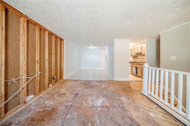 spare room with ornamental molding and a textured ceiling