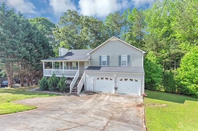 split level home with a garage, concrete driveway, a chimney, and covered porch