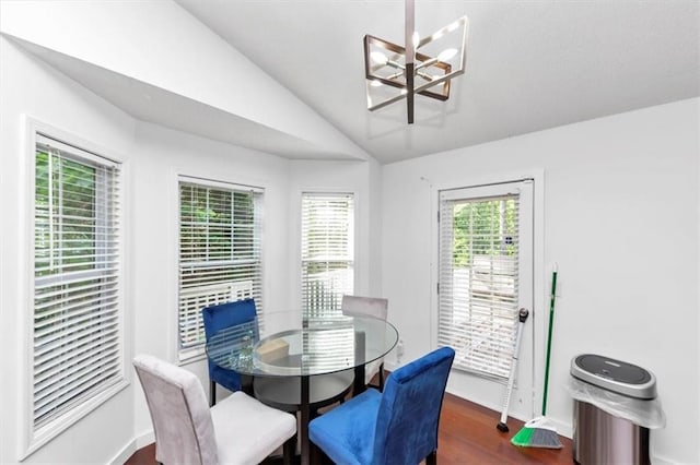 dining room featuring a chandelier, lofted ceiling, baseboards, and dark wood-type flooring