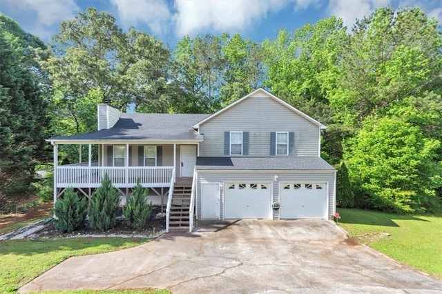 split level home featuring a porch, stairway, a garage, a chimney, and concrete driveway