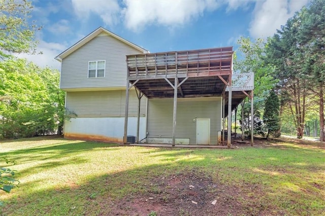back of house with a deck, a lawn, cooling unit, and a carport