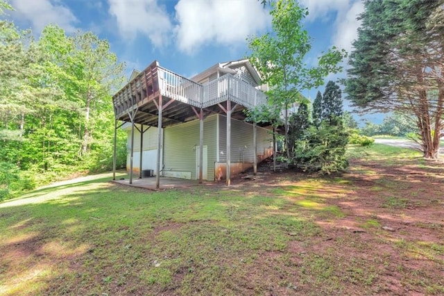 back of house with a deck, a yard, and a patio