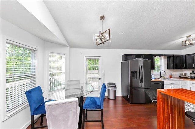 dining room featuring a chandelier, dark wood-style flooring, a textured ceiling, and baseboards