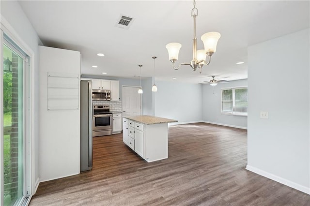 kitchen featuring stainless steel appliances, white cabinets, recessed lighting, dark wood-style flooring, and a chandelier