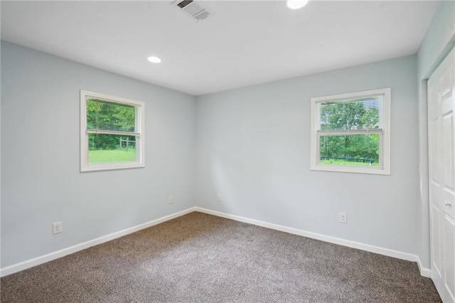 spare room with healthy amount of natural light, carpet flooring, baseboards, and recessed lighting