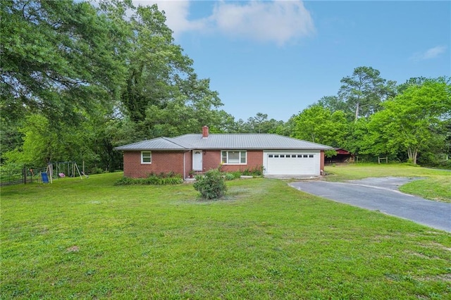single story home with asphalt driveway, a garage, a chimney, metal roof, and a playground