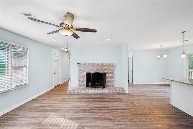 unfurnished living room with baseboards, wood finished floors, recessed lighting, ceiling fan, and a fireplace