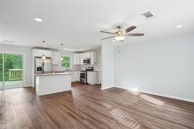 kitchen featuring appliances with stainless steel finishes, recessed lighting, decorative backsplash, white cabinets, and a ceiling fan