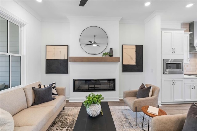 4933 Sudbrook Way Unit 230, Peachtree Corners, GA 30092 - living area featuring a ceiling fan, recessed lighting, light wood-style floors, crown molding, and a glass covered fireplace